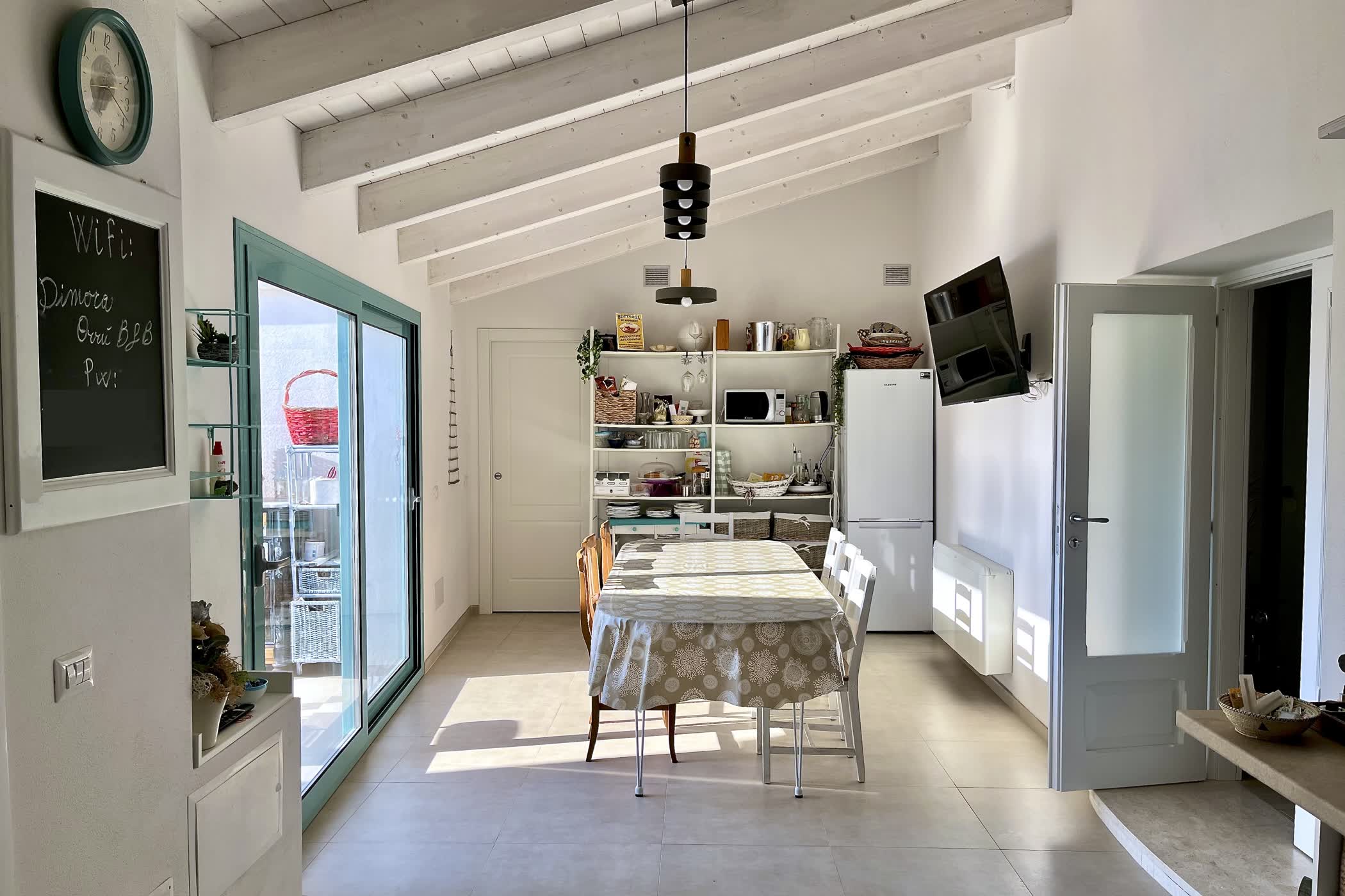 Sala colazione luminosa di Dimora Orrù con infissi turchesi